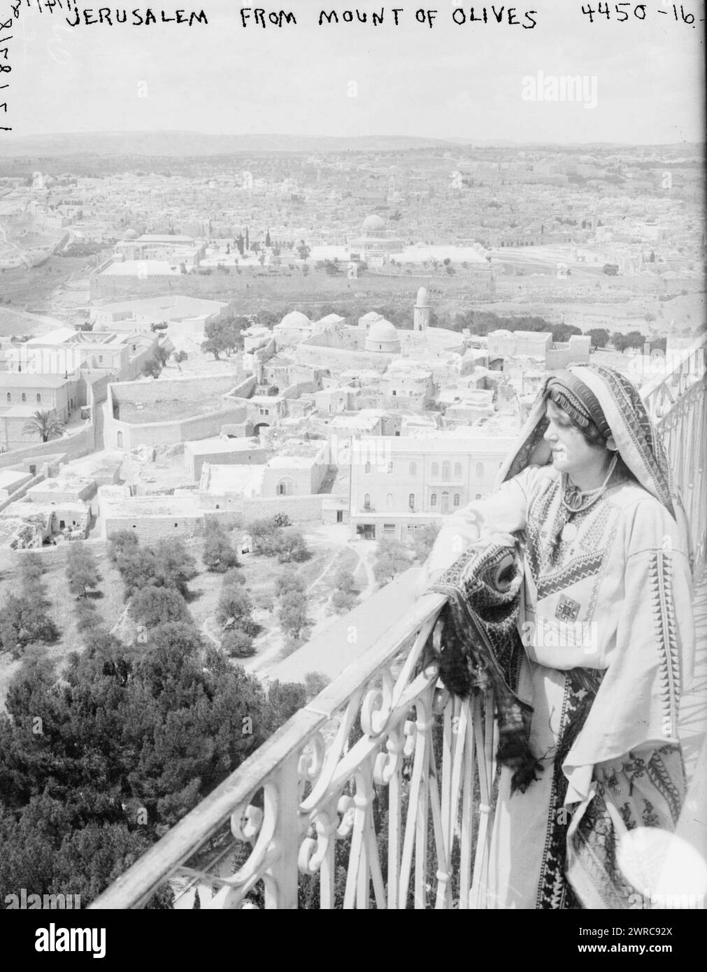 Jerusalem from Mount of Olives, Photograph shows a woman in a traditional embroidered Palestinian dress and headdress, standing on balcony on the Mount of Olives overlooking Jerusalem., 1918 Jan. 14, Jerusalem, Glass negatives, 1 negative: glass Stock Photo