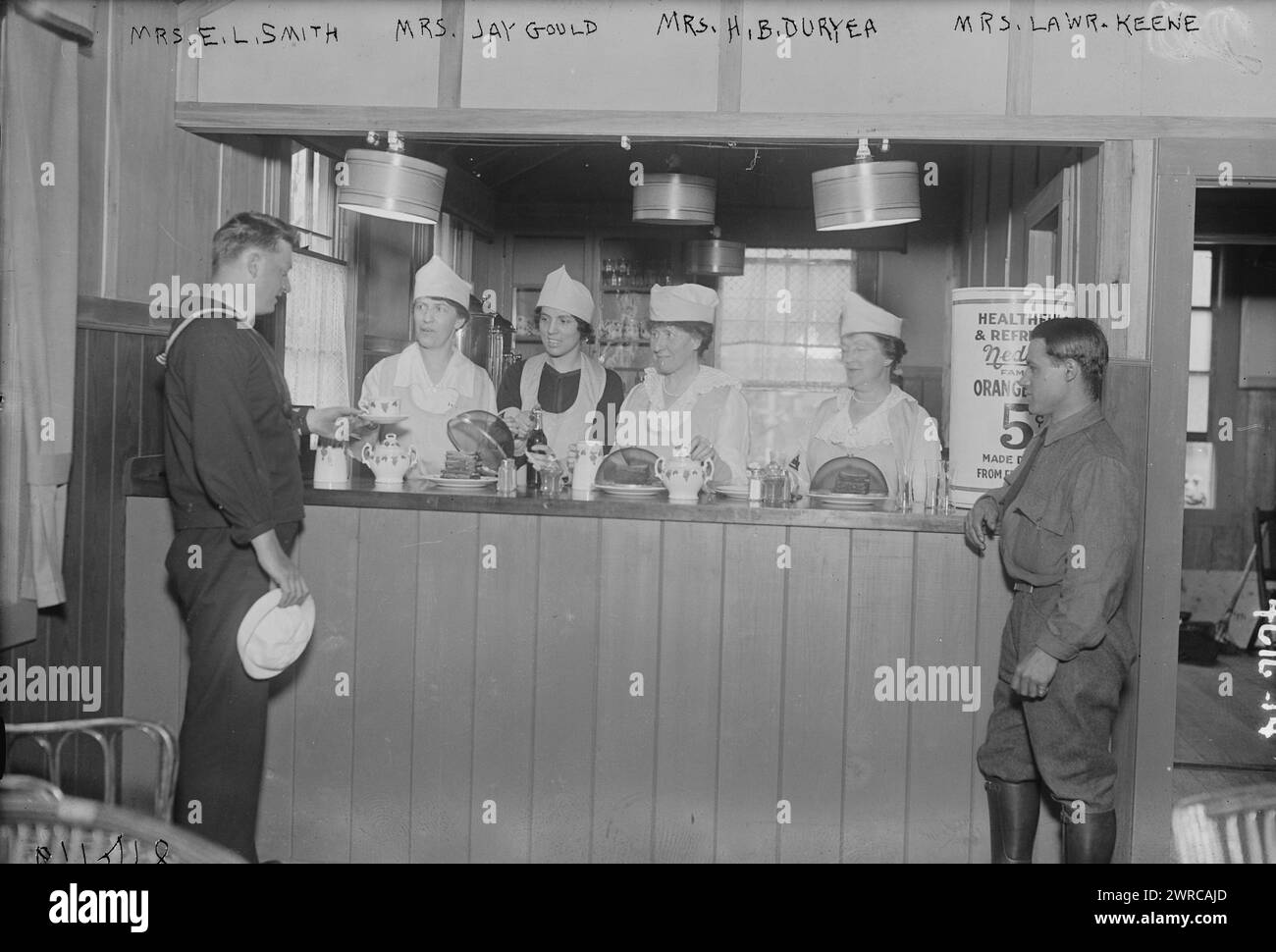 Mrs. E.L. Smith, Mrs. Jay Gould, Mrs. H.B. Duryea, Mrs. Lawr. Keene, Photograph shows Mrs. Edward L. Smith, Mrs. Jay Gould, Mrs. Herman B. Duryea (Ellen Homer Winchester), and Mrs. Lawrence Keene behind a counter, serving military personnel at the Y.M.C.A. Bryant Park Eagle Hut, New York City which was opened during World War I., 1918, World War, 1914-1918, Glass negatives, 1 negative: glass Stock Photo