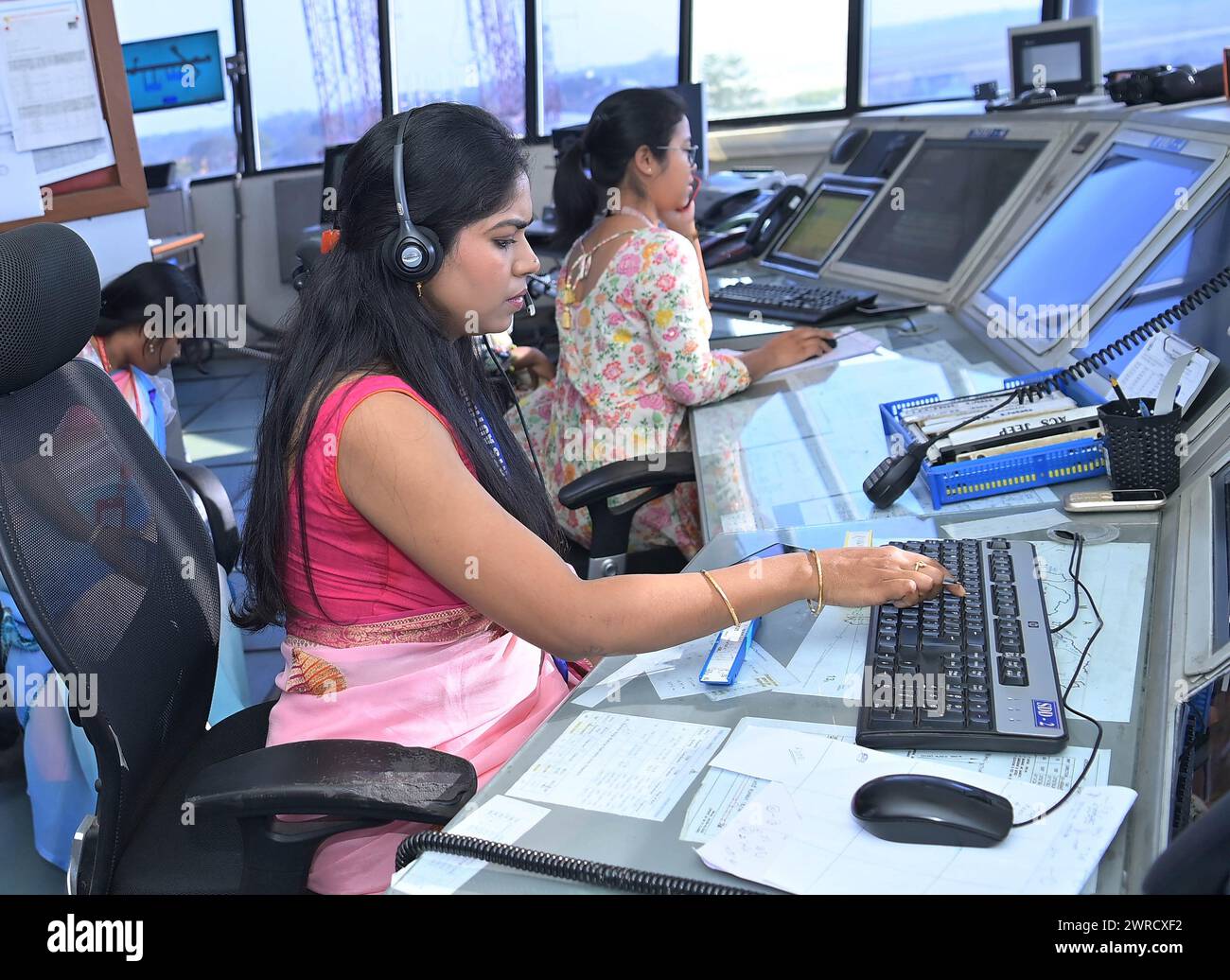 Female traffic controllers, Bipasha Hrangkhawl, Disha Chandra, and Chaya, take charge of traffic management at the Agartala airport's ATCT Tower to celebrate International Women's Day. Tripura, India. Stock Photo