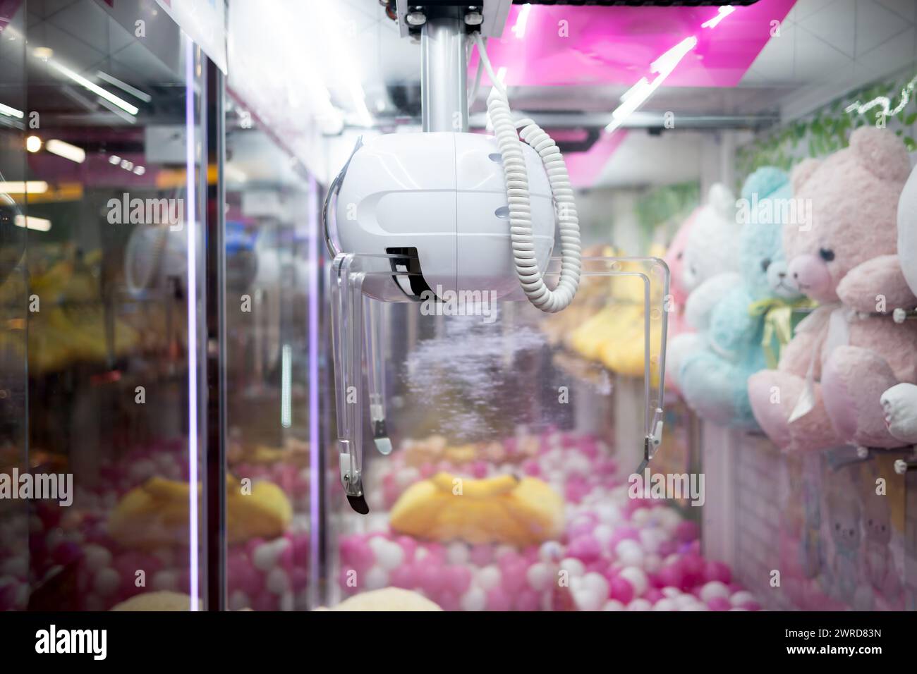 Claw machine crane game catcher at an arcade amusement game center. Stock Photo