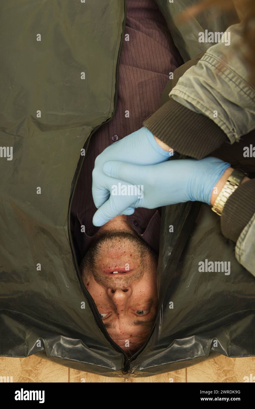 Crime scene investigation - dead man placed in body bag Stock Photo