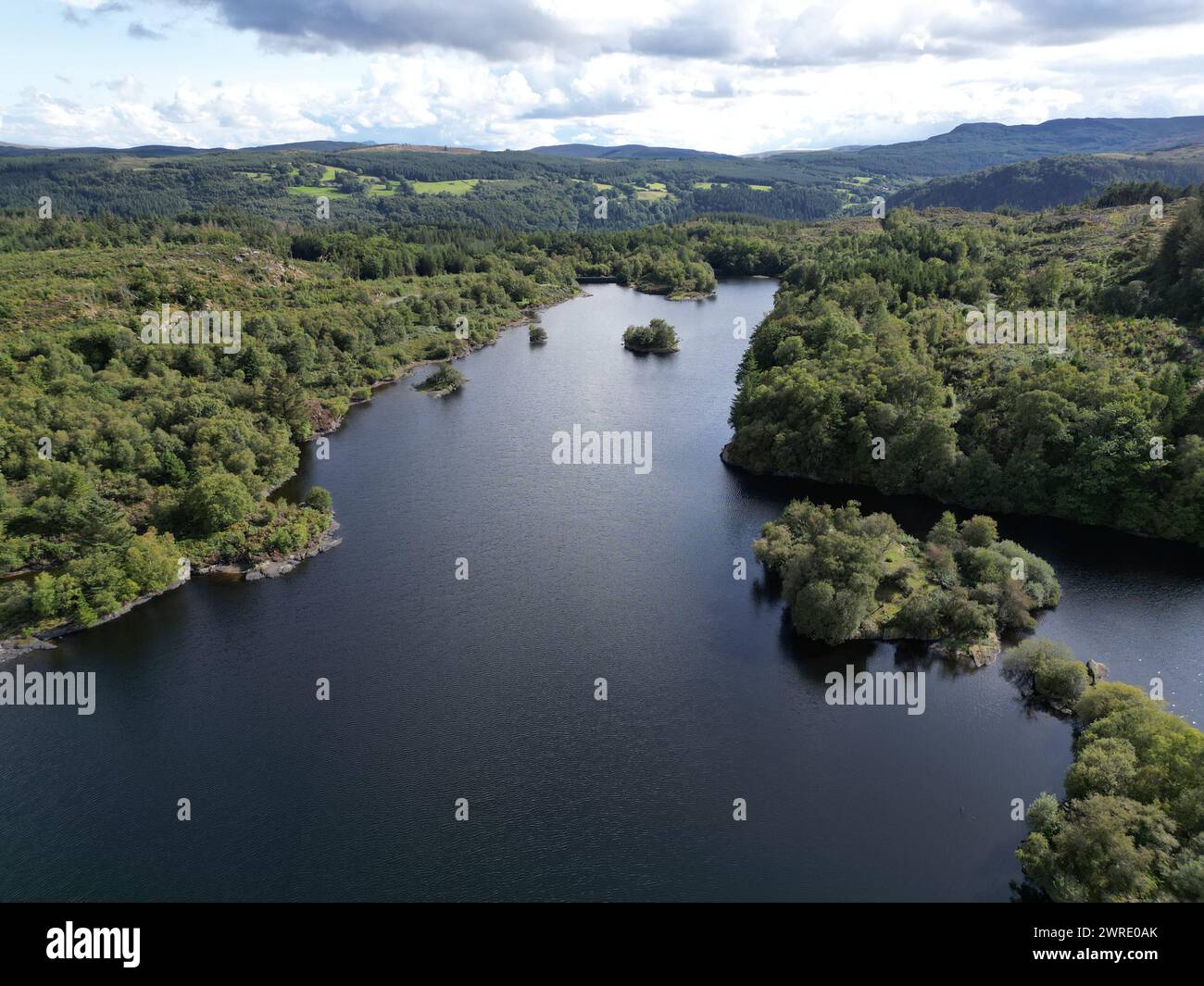 An aerial view of a lake encircled by lush green foliage Stock Photo ...