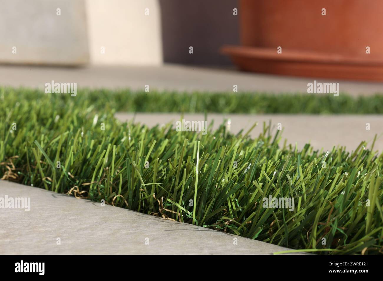 close view of green synthetic grass texture between tiles Stock Photo ...