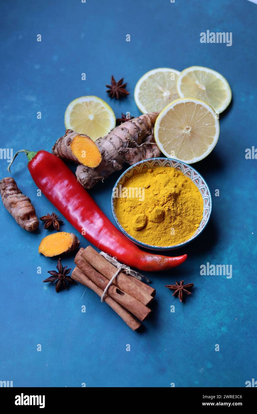 Ginger, lemon, turmeric, cinnamon sticks, anise star, garlic bulb, horseradish on a blue background with copy space. Cold and flu season concept. Stock Photo