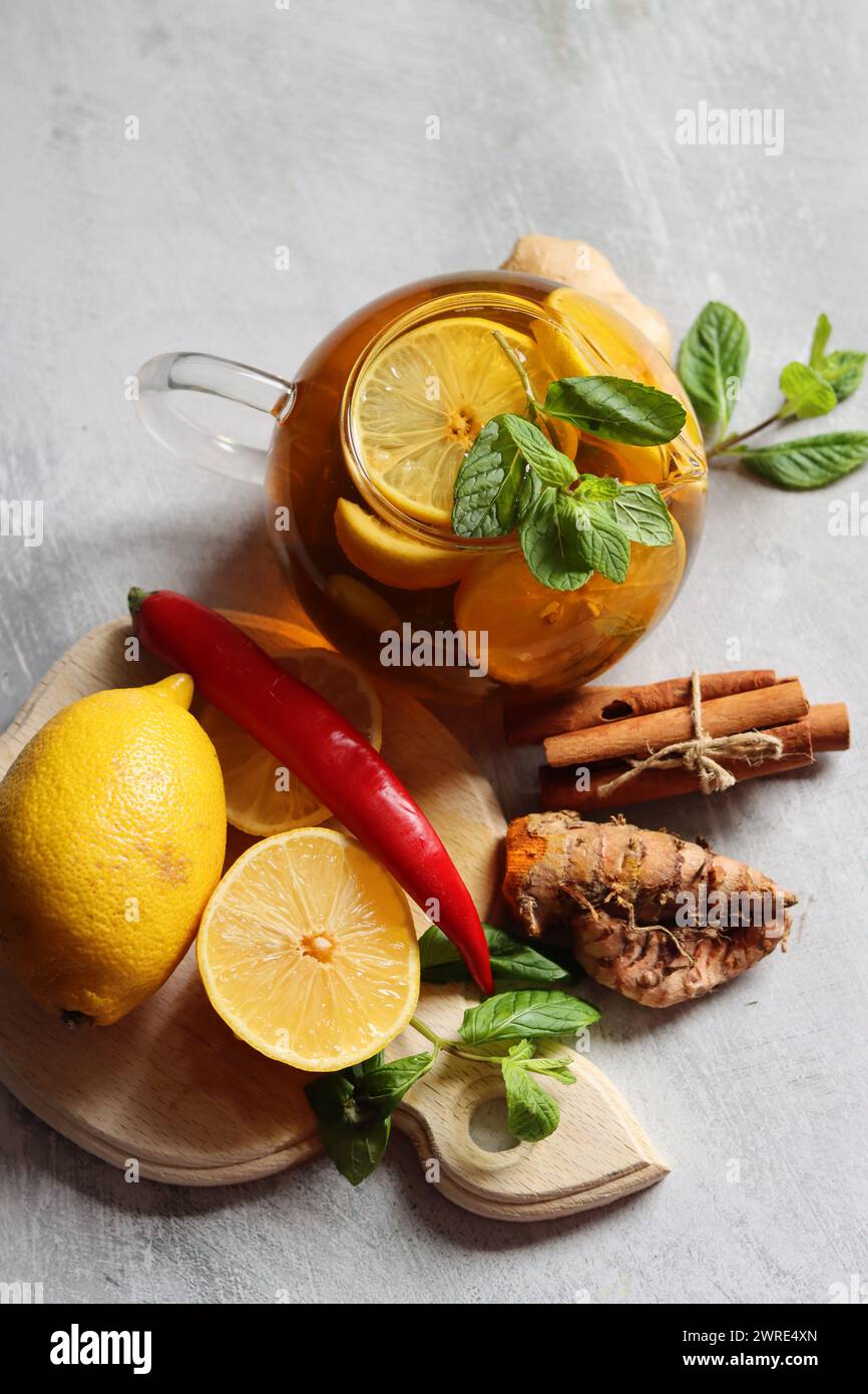 Herbal tea with mint, ginger, lemon and spices on textured background with copy space. Homemade medicine concept.Natural organic drink for cold period Stock Photo