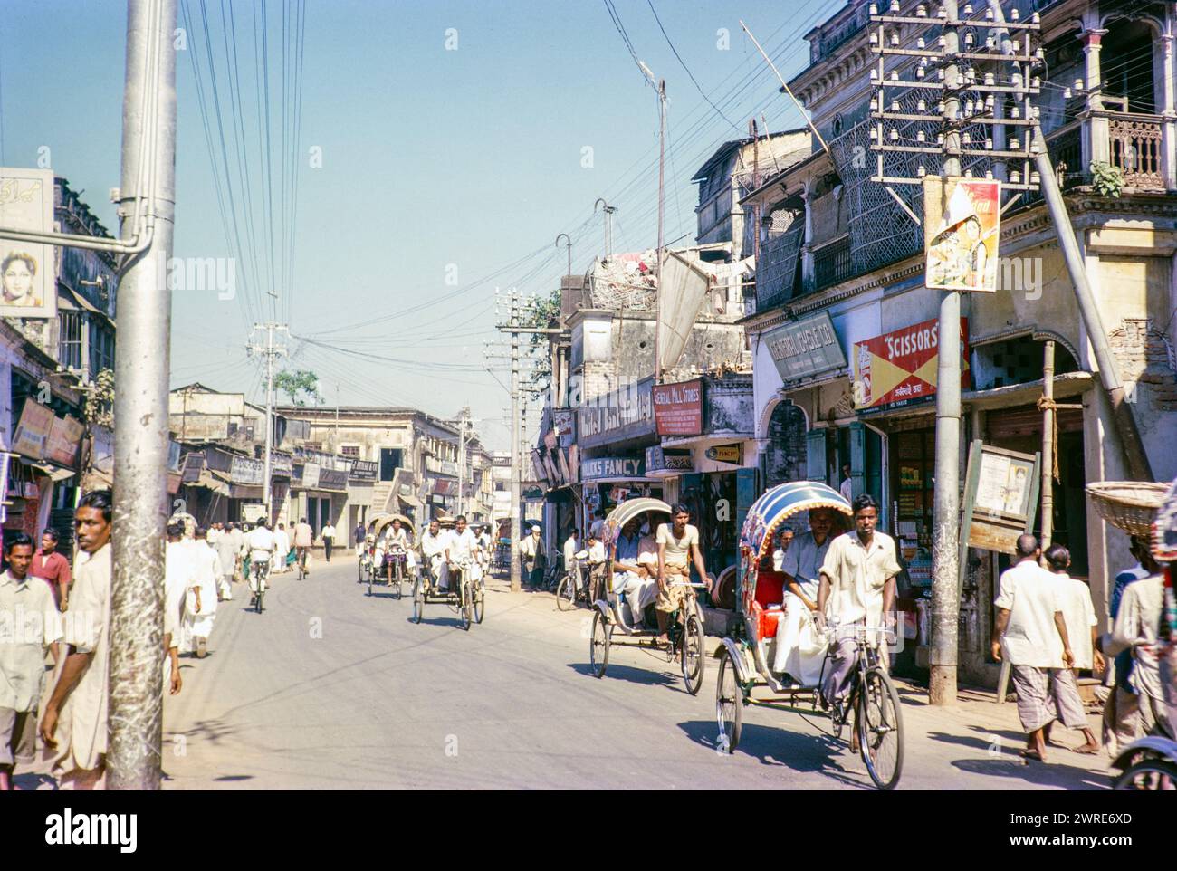 Cysle ricksahws and people walking on city centre street, Dhaka, Bangladesh, Asia 1962 Stock Photo