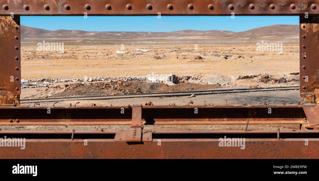 Uyuni train cemetery with desert landscape and rusted train wagon, Uyini, Bolivia. Stock Photo