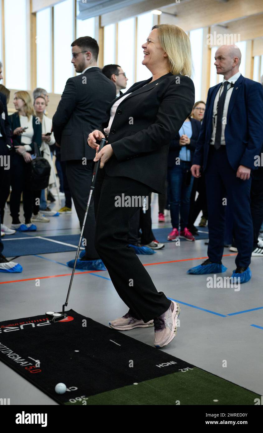 Berlin, Germany. 12th Mar, 2024. Nancy Faeser (SPD), Federal Minister of the Interior and Home Affairs, holds a golf club during a tour of a sports course at the second 'Movement Summit' in the sports hall of the sports school in Berlin's Olympic Park. The event, organized by the Federal Ministry of the Interior and Home Affairs and the Federal Ministry of Health, focuses on the question of how sport and exercise can be promoted and the political and social framework conditions improved. Credit: Bernd von Jutrczenka/dpa/Alamy Live News Stock Photo
