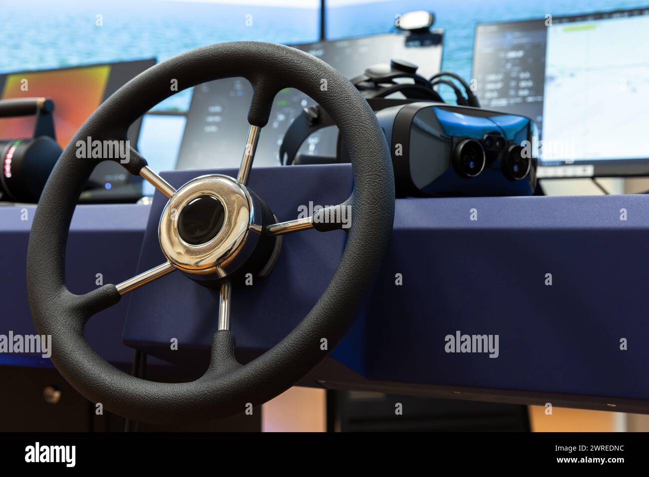 Marine navigation simulation system, ship control panel with steering wheel and VR headset on the desk Stock Photo