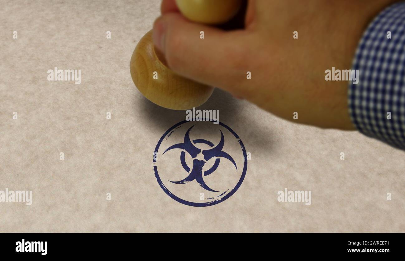 Biohazard warning stamp and stamping hand. Biological hazard symbol concept. Stock Photo