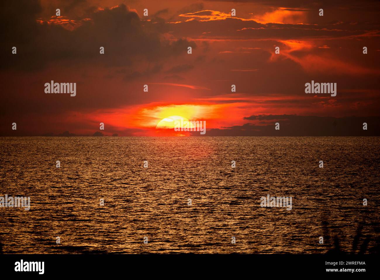 Golden sun setting into sea, red dark sky. Sri Lanka. Stock Photo