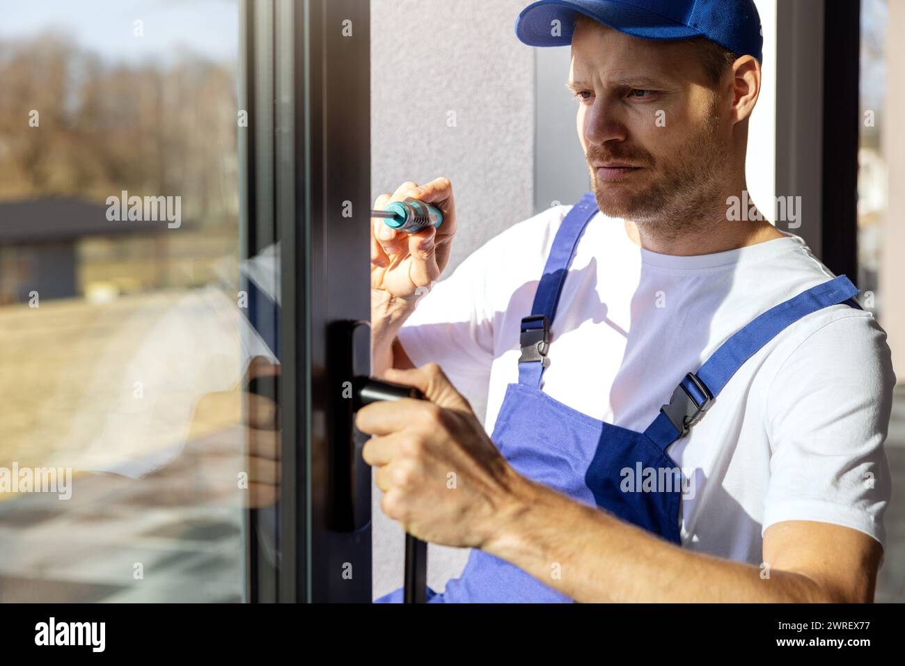 worker installing and adjusting aluminium frame sliding terrace doors Stock Photo