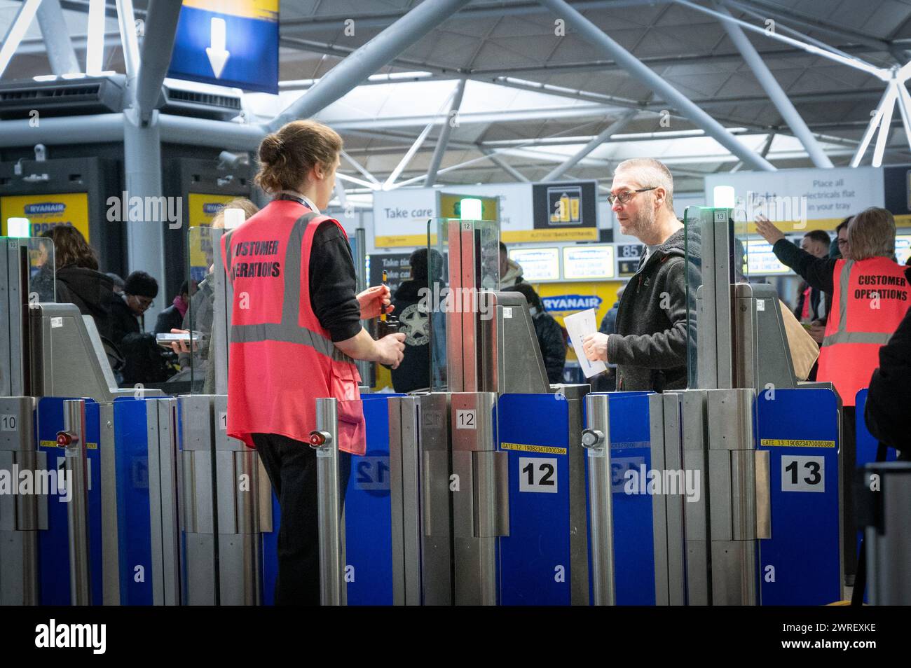 Man talking to Customer operations staff at the security gate in Stansted airport , London Stock Photo