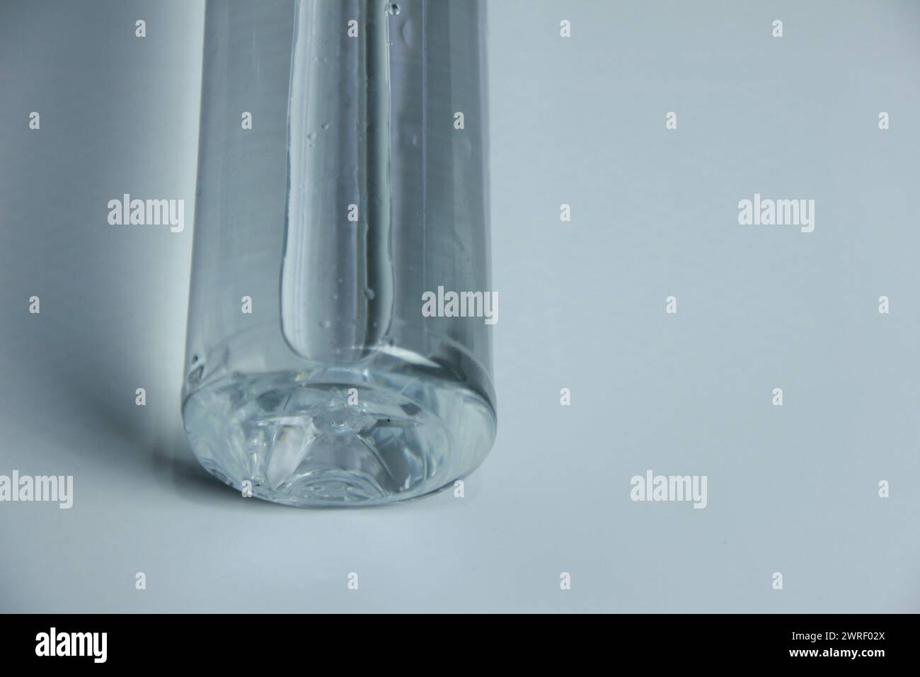 A glass vase with water on a table Stock Photo