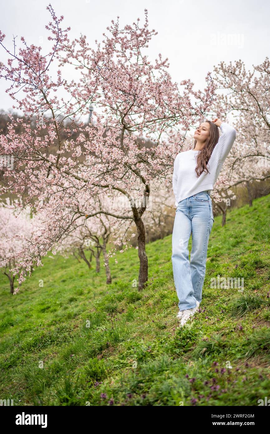 Lovely young woman in a blooming pink and white garden Petrin in Prague ...