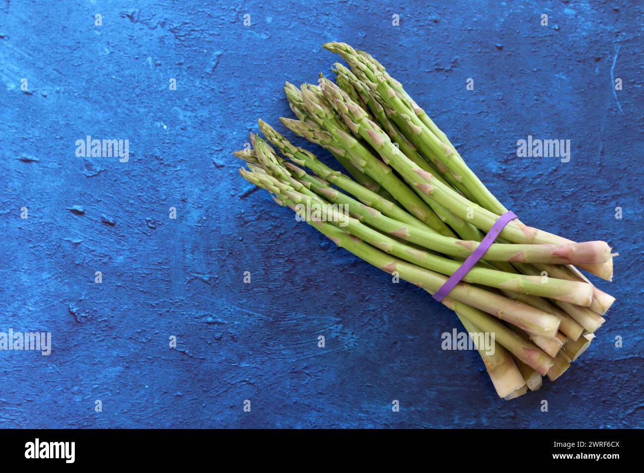 Bunch of fresh green asparagus close up  photo. Raw asparagus top view. Healthy eating concept. Natural vitamins and antioxidants. Stock Photo