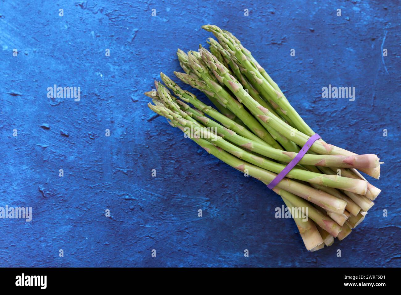 Bunch of fresh green asparagus close up  photo. Raw asparagus top view. Healthy eating concept. Natural vitamins and antioxidants. Stock Photo