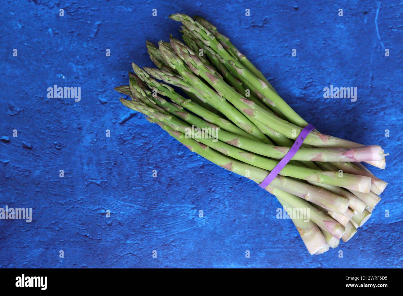 Bunch of fresh green asparagus close up  photo. Raw asparagus top view. Healthy eating concept. Natural vitamins and antioxidants. Stock Photo