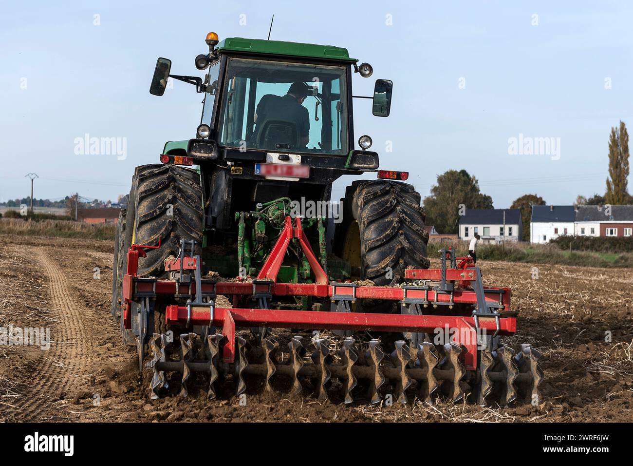 La couche superieur de la terre est grattee et aeree par un tacteur ...