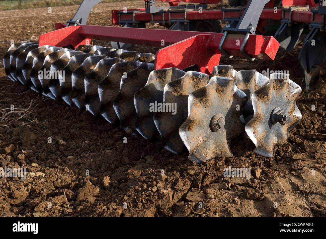 La couche superieur de la terre est grattee et aeree par un tacteur ...