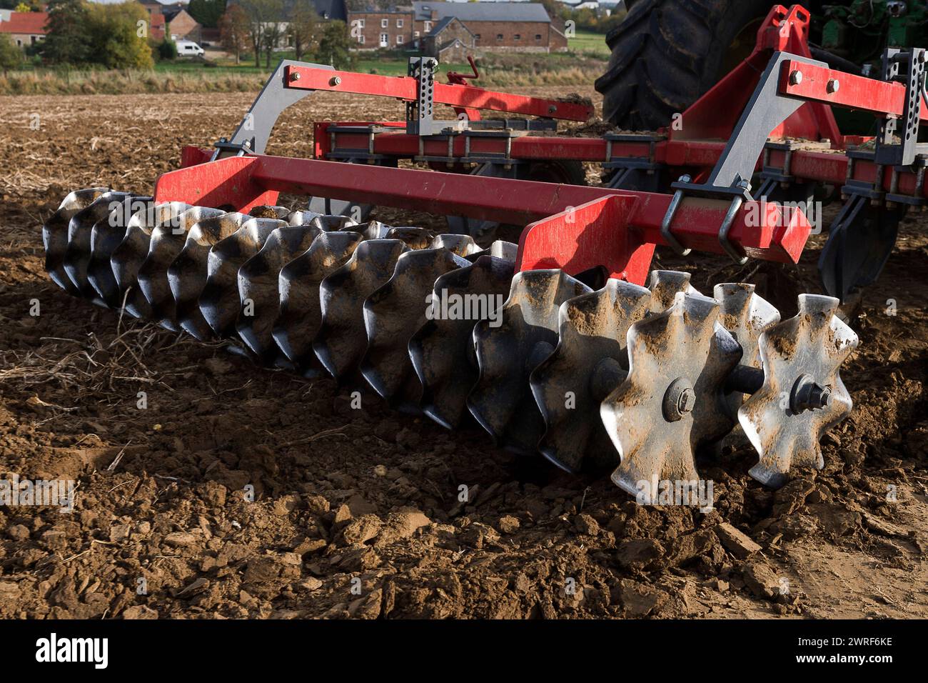 La couche superieur de la terre est grattee et aeree par un tacteur ...