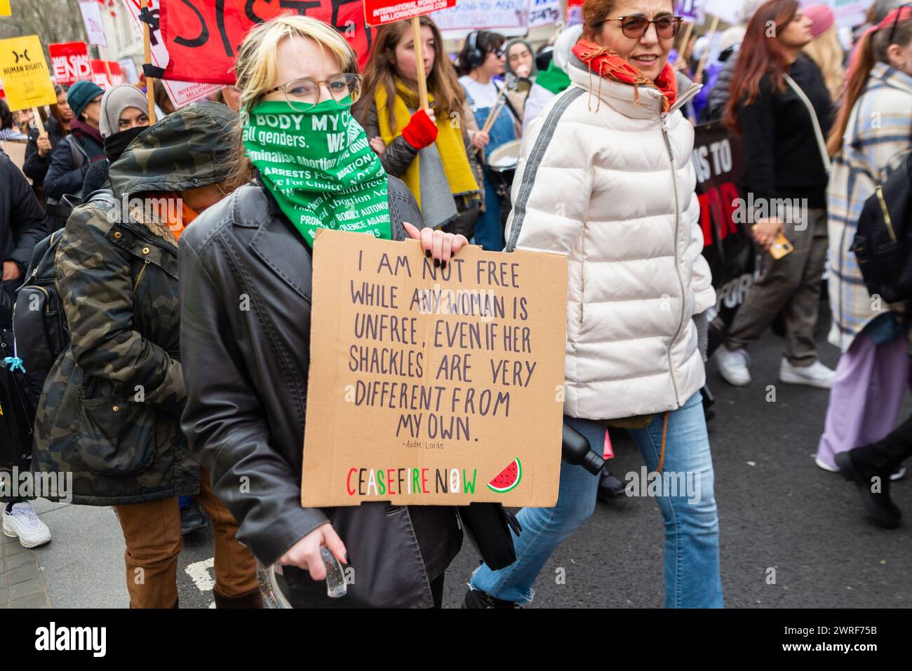 Million Women Rise march, part of International Women's Day 2024. Protest against oppression, inequality, rights & violence. Audre Lorde quote Stock Photo