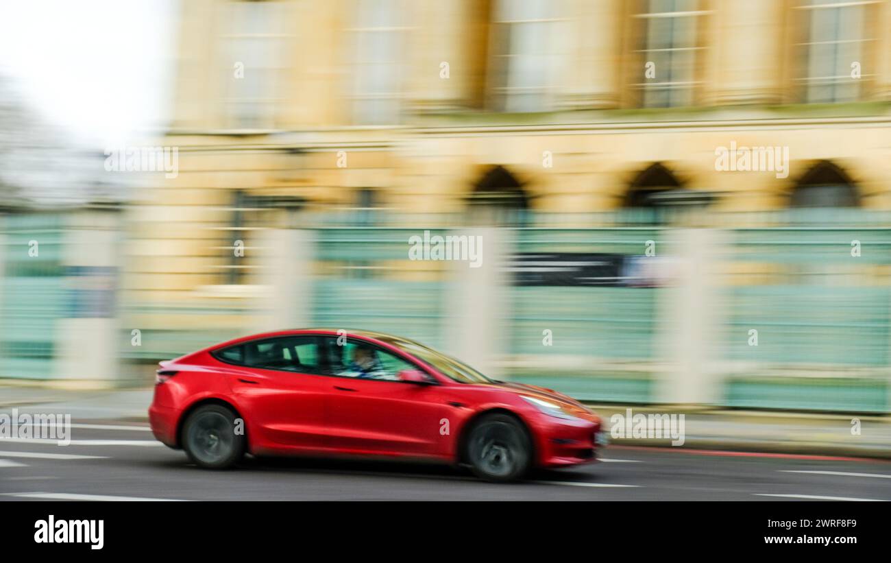 LONDON- FEBRUARY 19, 2024:  Tesla Model 3 in motion blur on London street Stock Photo