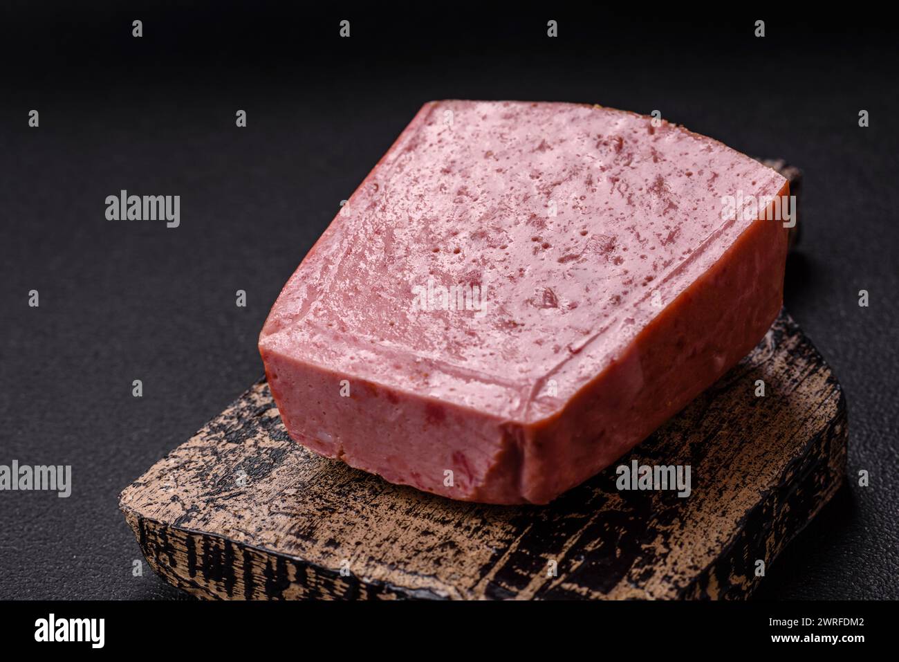 Delicious canned pink ham with salt, spices and herbs on a dark ...