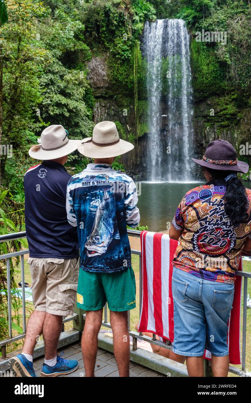 Australian tourists wearing hats and colourful shirts and flying a drone at Millaa Millaa Falls, Atherton Tablelands, Queensland, Australia Stock Photo