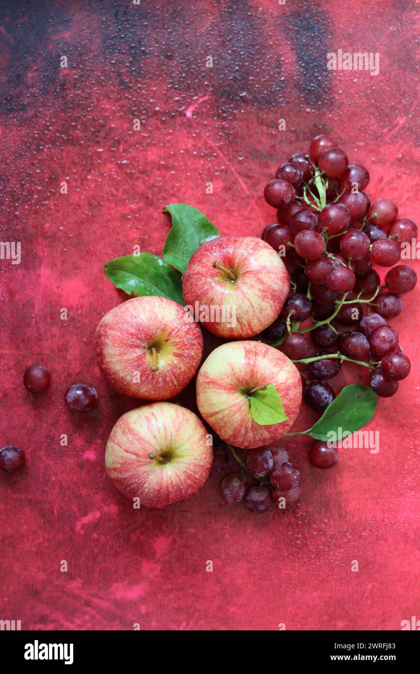 Still life with red apples on textured red background. Space for text. Healthy eating concept. Stock Photo