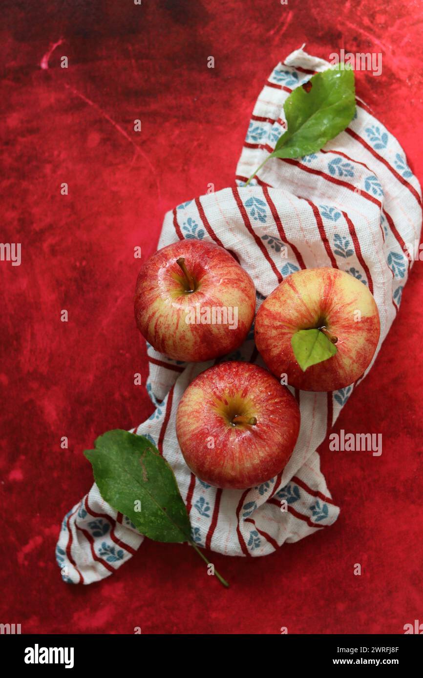 Still life with red apples on textured red background. Space for text. Healthy eating concept. Stock Photo