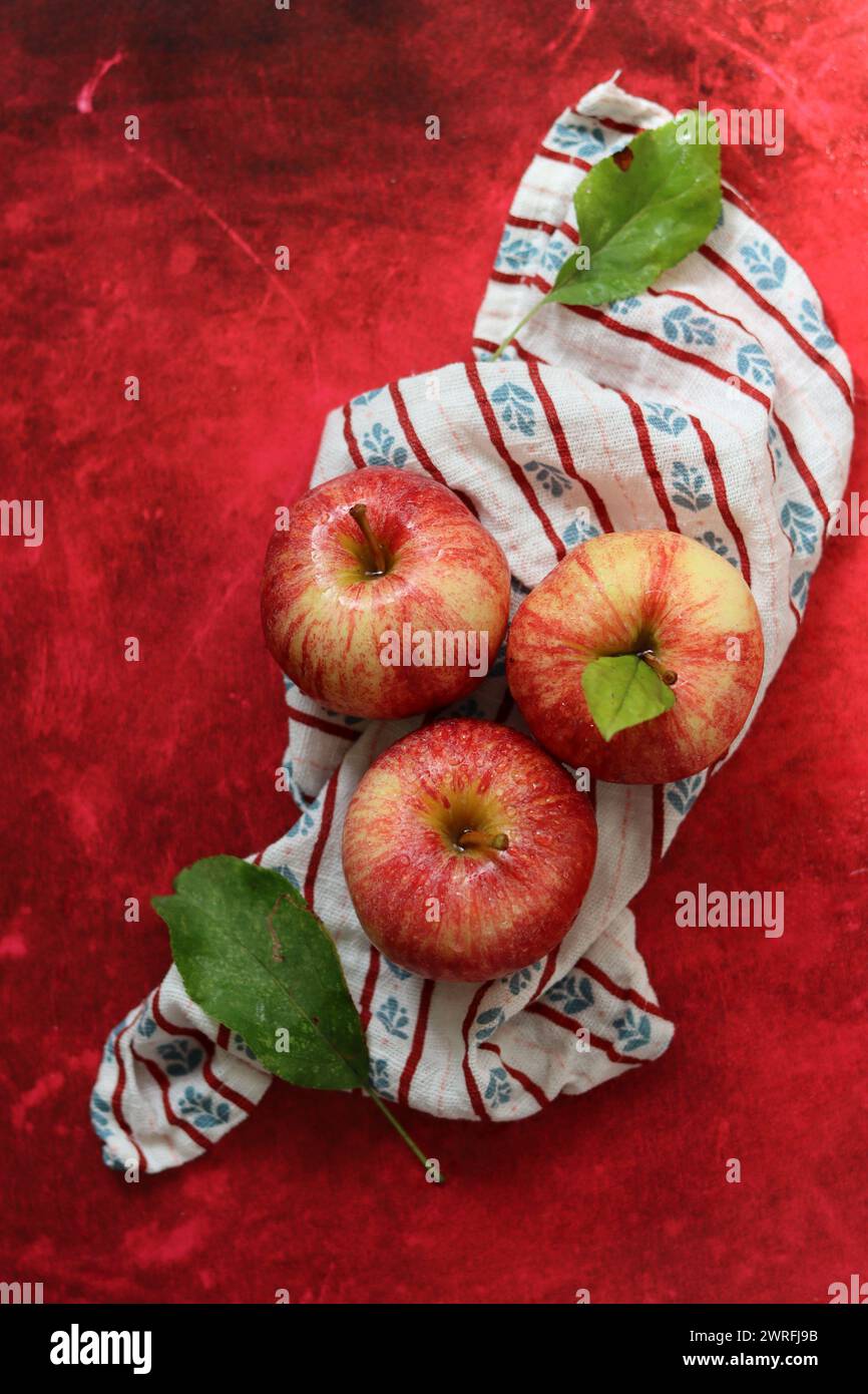 Still life with red apples on textured red background. Space for text. Healthy eating concept. Stock Photo