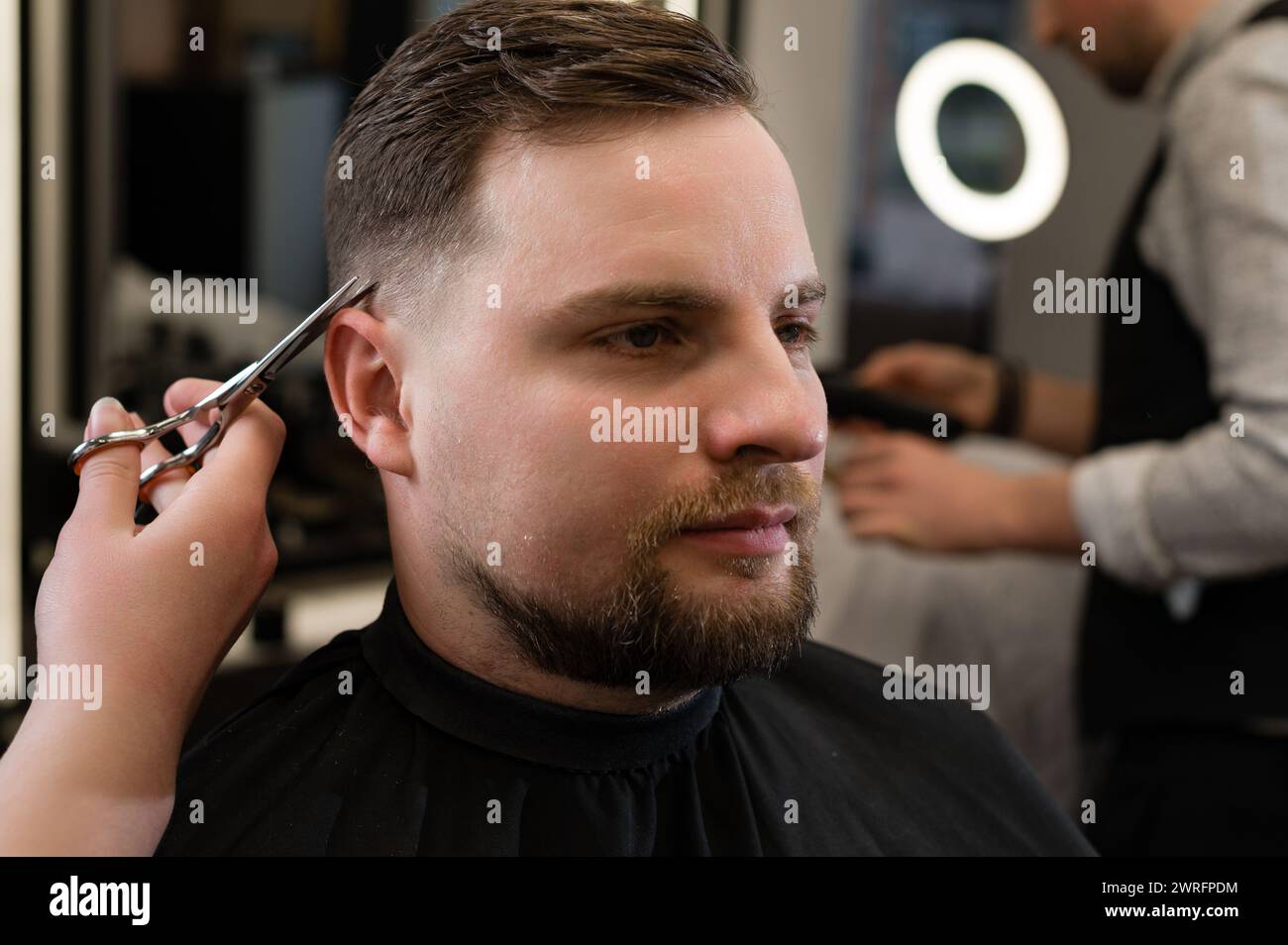 Haircut and alignment of the contour of the head with scissors. Short ...