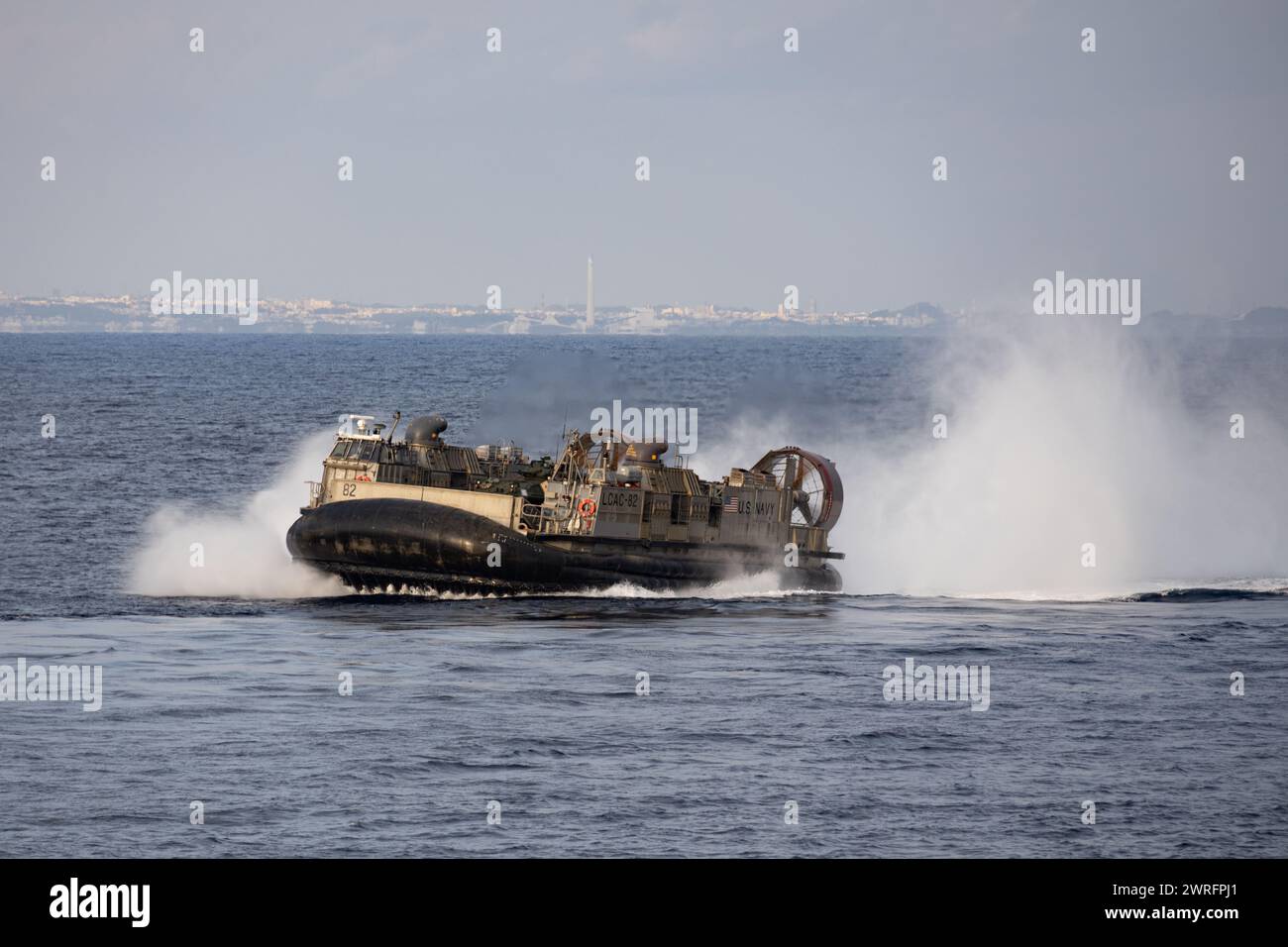 U.S. Navy landing craft, air cushion (LCAC) pilots wade across the sea ...