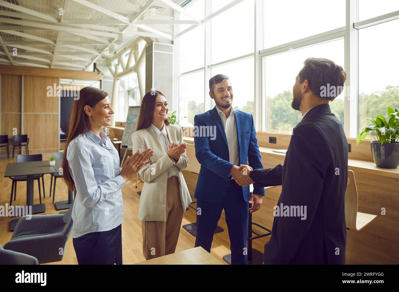Business people meet new office colleague, handshake to greet, congratulate Stock Photo
