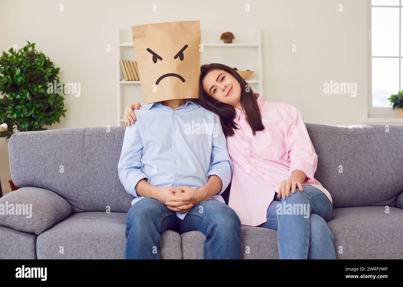 Loving, smiling wife trying to reconcile with husband who's still mad after fight Stock Photo