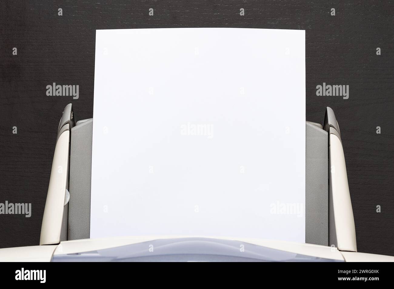 High angle shot of blank sheets of paper coming out of an computer