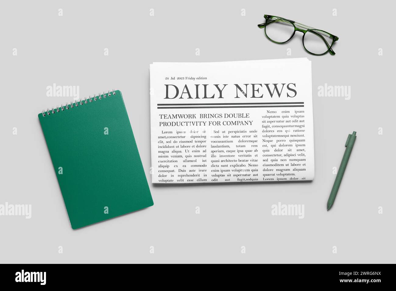 Newspaper with pen and glasses on grey background. Top view Stock Photo
