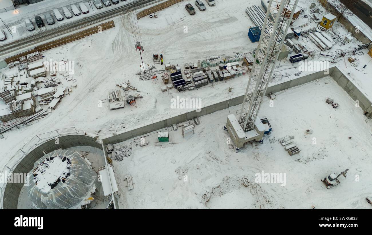 Drone photography of a construction site in a city covered by snow during winter cloudy day Stock Photo