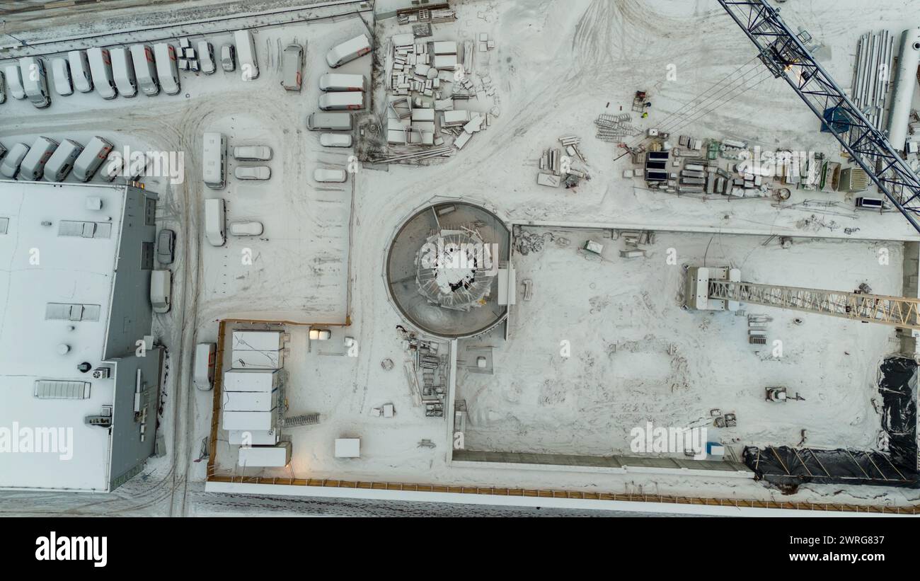 Drone photography of a construction site in a city covered by snow during winter cloudy day Stock Photo