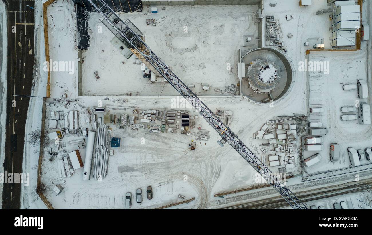 Drone photography of a construction site in a city covered by snow during winter cloudy day Stock Photo