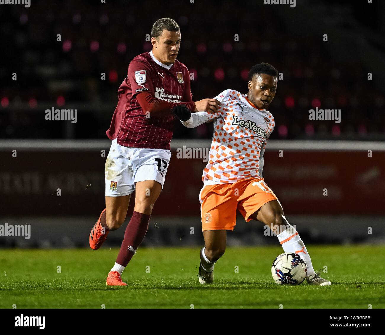 Karamoko Dembele of Blackpool battles for the ball Shaun McWilliams of Northampton Town the Sky Bet League 1 match Northampton Town vs Blackpool at Sixfields Stadium, Northampton, United Kingdom, 12th March 2024  (Photo by Craig Thomas/News Images) Stock Photo