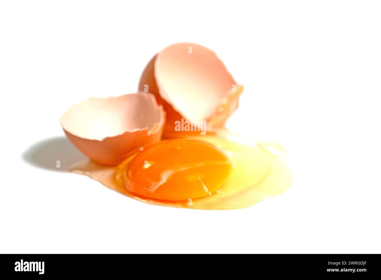Cracked brown chicken egg against a white background Stock Photo