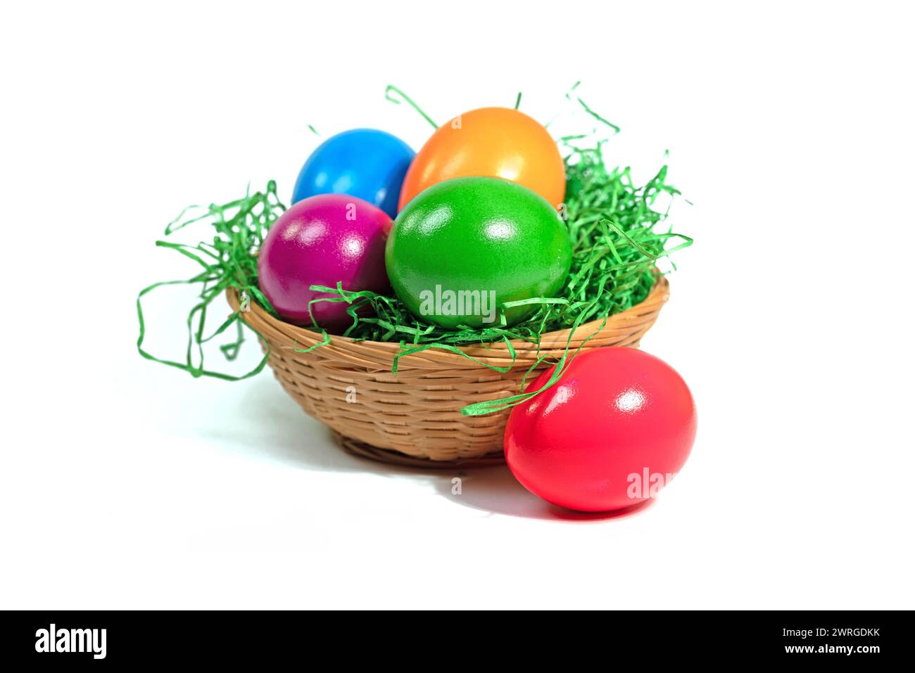 Colorful Easter eggs in a basket against a white background Stock Photo