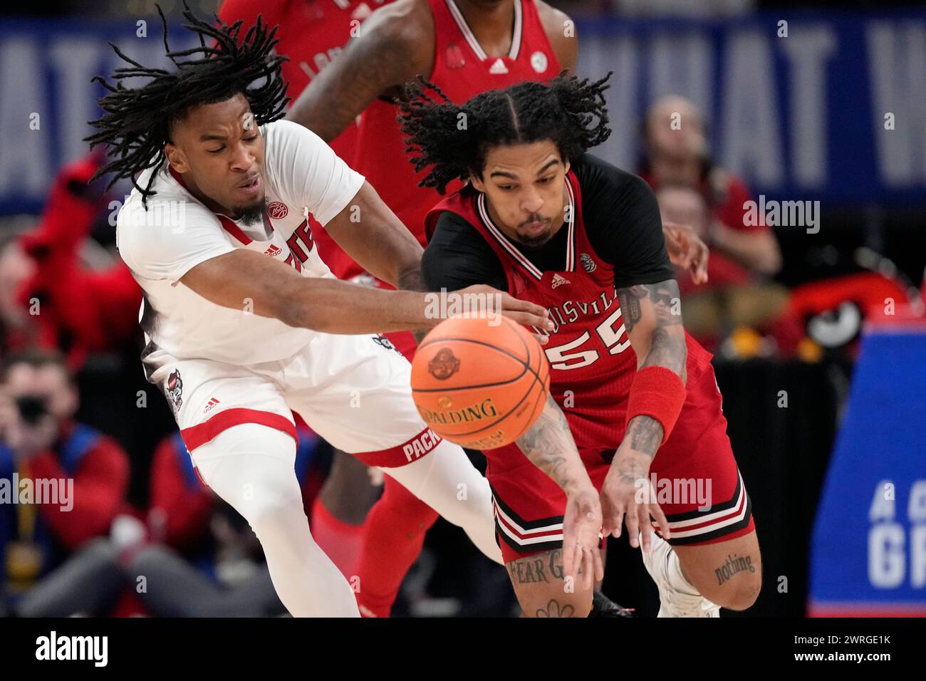 Louisville guard Skyy Clark (55) steals the ball from North Carolina State guard Jayden Taylor