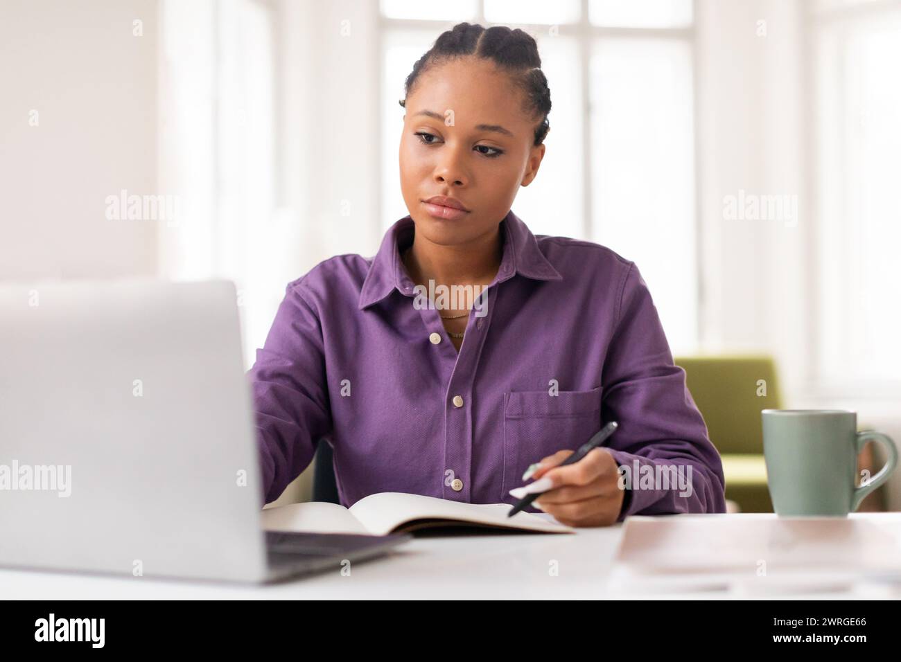 Focused african american female teen student studying with laptop and ...