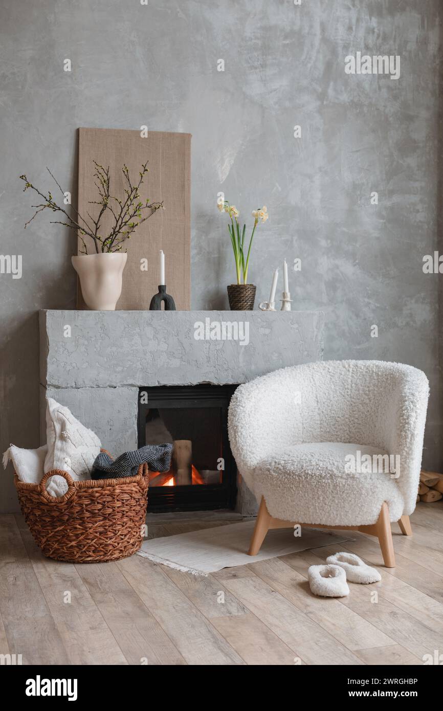 Armchair in front of a cosy fireplace in a stylish living room Stock Photo