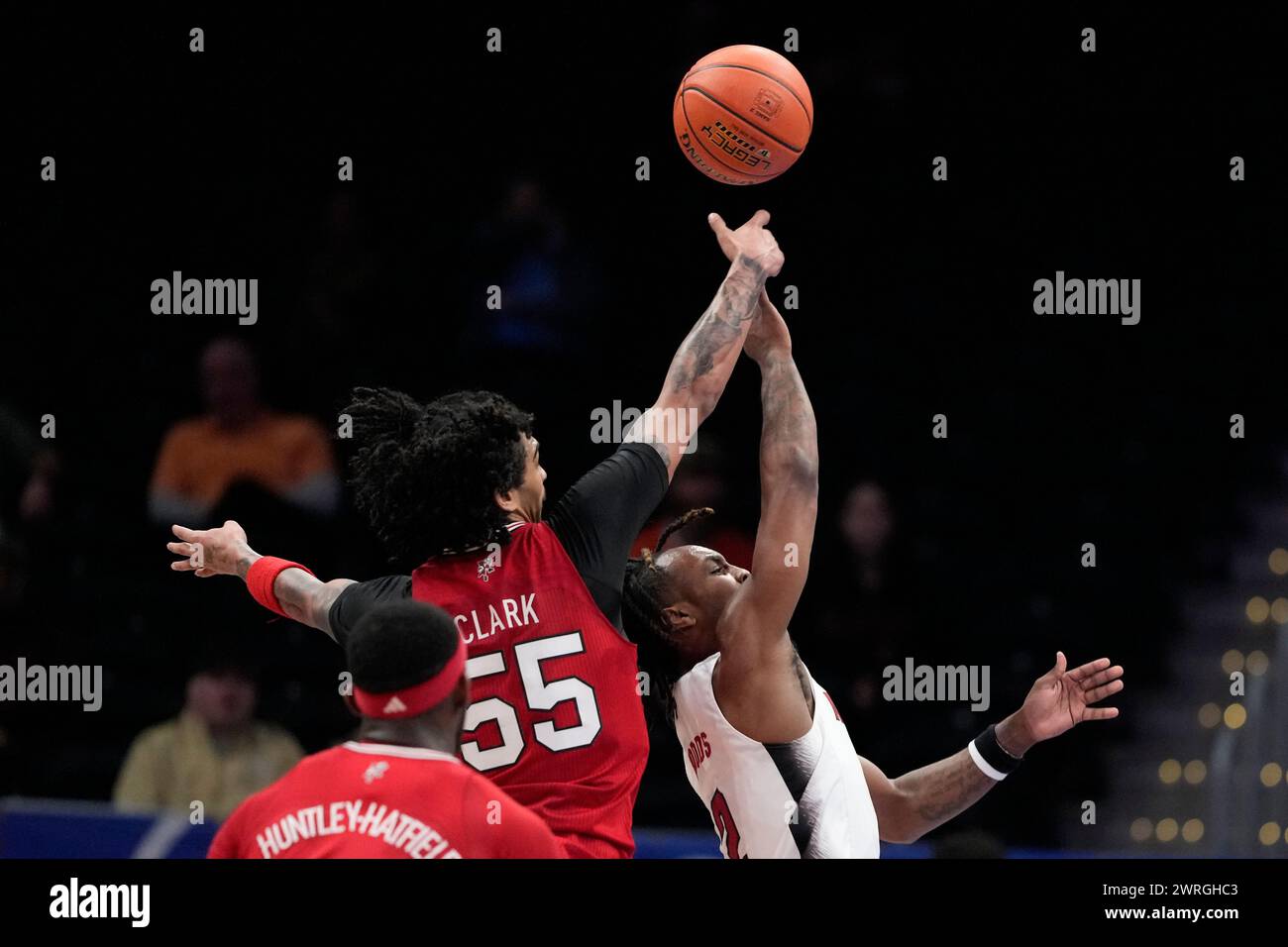 Louisville guard Skyy Clark (55) blocks a shot by North Carolina State guard Kam Woods (2
