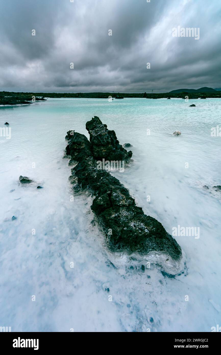 Black lava rocks in Blue Lagoon under a moody grey sky, Iceland Stock ...