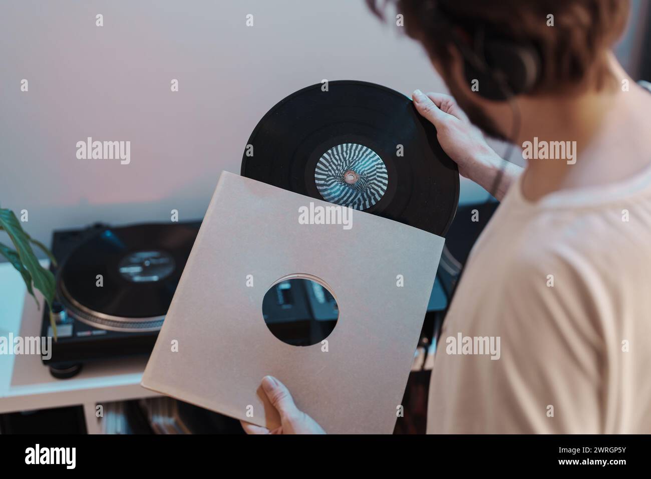 Music enthusiast holding vinyl record next to turntable Stock Photo - Alamy